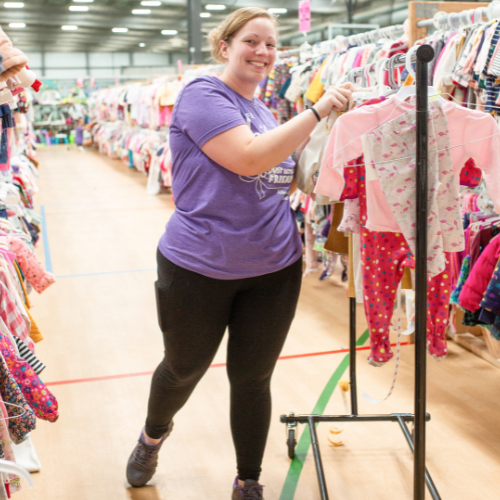 Mom with clothing rack at JBF drop off.